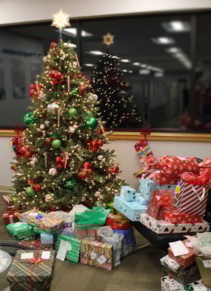 Adopt-a-Family - Christmas tree with many gifts to be donated to a local family