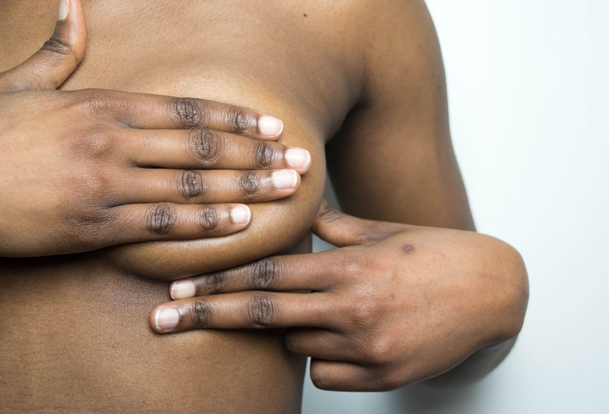 African-American woman checking for lumps in breast