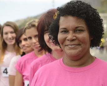 African American woman with pink shirt and other women lined up behind her