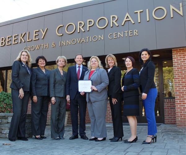 Beekley leadership team with Senator Blumenthal and staff, standing in front of Beekley Corporation, holding recognition certificate