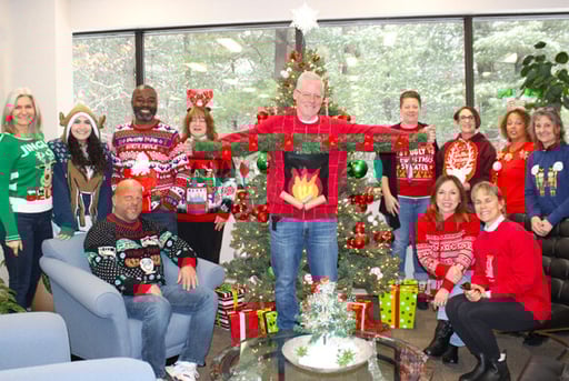 Beekley Associates rocking their "Ugly Sweaters" - group of associates in front of Christmas tree