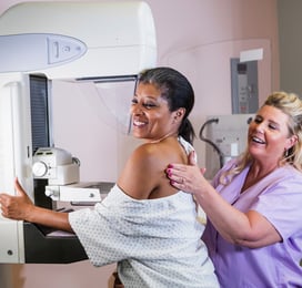 A technologist helps position a patient on a mammogram with Bella Blankets