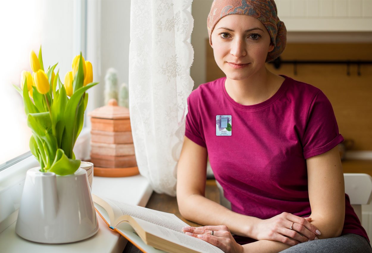 Cancer patient relaxing, wearing an Elequil Aromatabs aromatherapy product