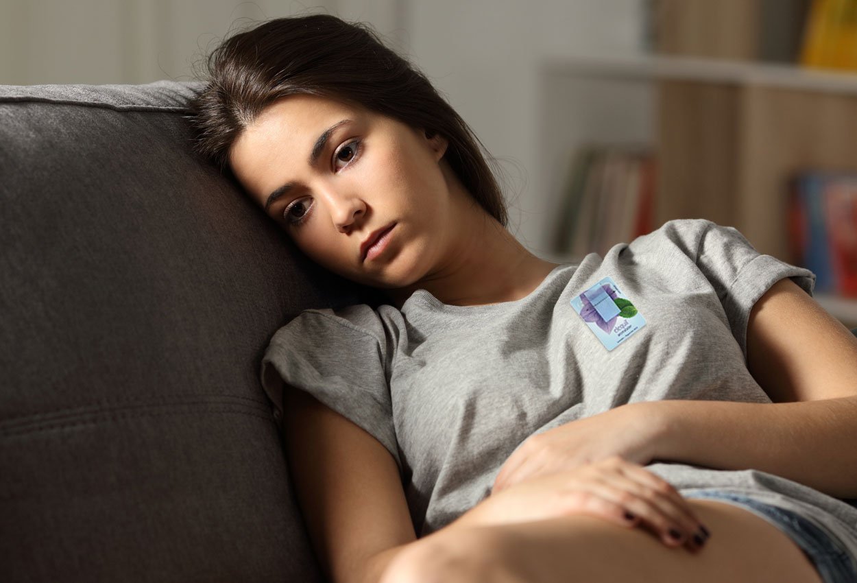 women on a sofa, looking anxious