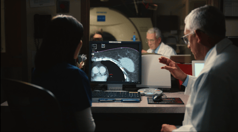 A doctor and technologist reviewing radiation treatment plan on screen