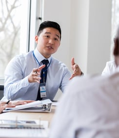 An innovator discussing his product line with others at a table.