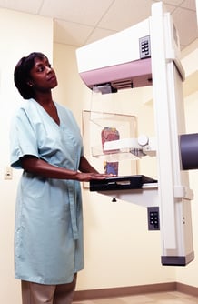 A patient at a mammography machine.