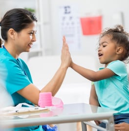A nurse high-fiving a pediatric patient.