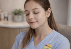 nurse in break room with her eyes closed relaxing with an Elequil Aromatab on her scrubs