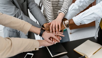Employees with their hands in the middle