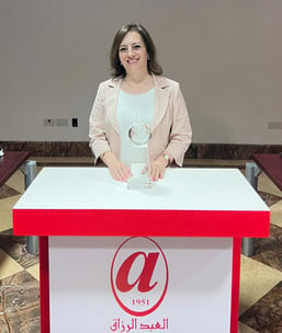photo of Lina Muniemena with award and standing behind podium