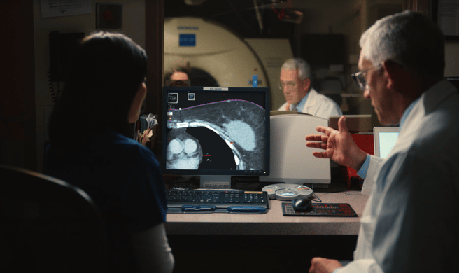Two healthcare professionals reviewing a patient's CT scan before radiation treatment