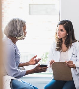A doctor listening to a patient discussing concerns.