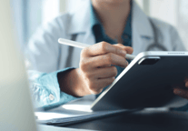 medical professional with pen and tablet