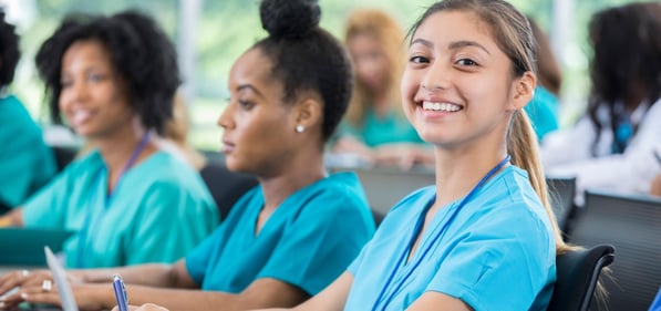 Nurses in a training program with one smiling at the camera.