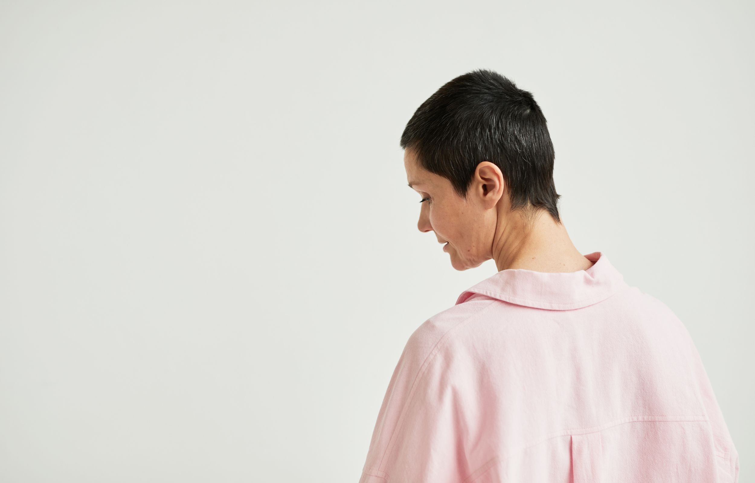 A woman in a hospital gown looking away from the camera